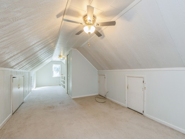 bonus room with vaulted ceiling, ceiling fan, and light colored carpet