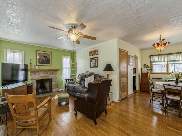 living room with a textured ceiling, a fireplace, hardwood / wood-style floors, and a wealth of natural light