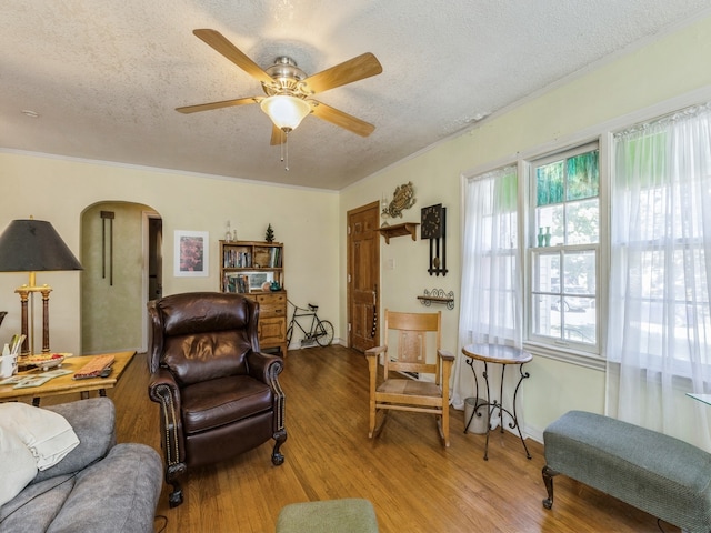 sitting room with a textured ceiling, ornamental molding, ceiling fan, and hardwood / wood-style flooring