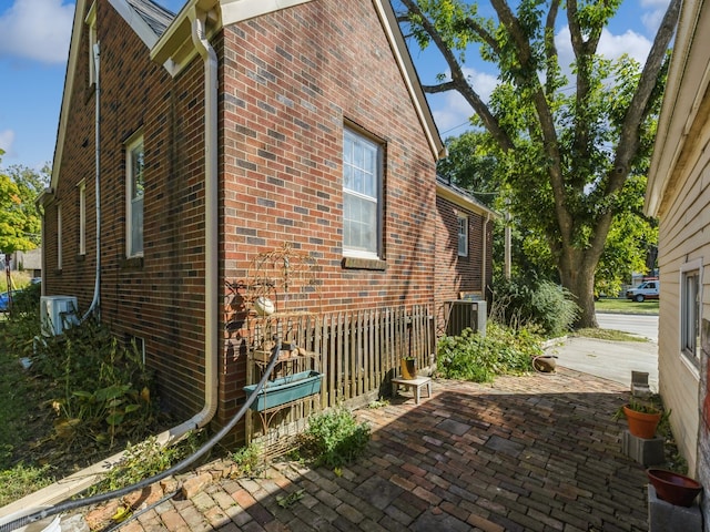 view of side of property featuring a patio and central AC