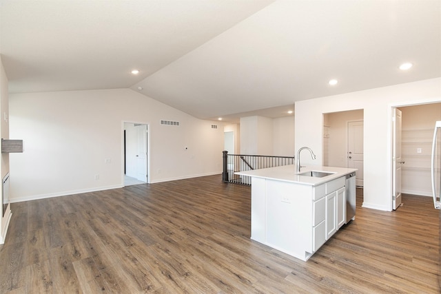 kitchen with white cabinetry, sink, hardwood / wood-style floors, lofted ceiling, and a center island with sink