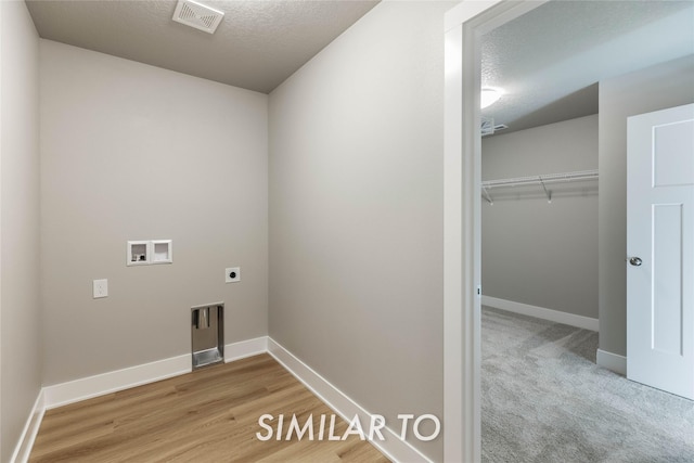 laundry area featuring hookup for an electric dryer, washer hookup, and a textured ceiling