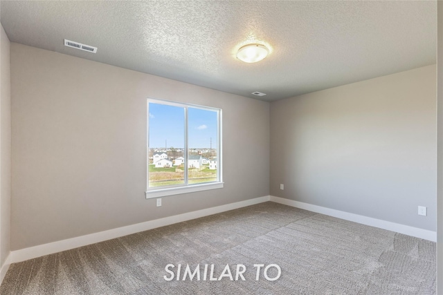 unfurnished room featuring carpet flooring and a textured ceiling