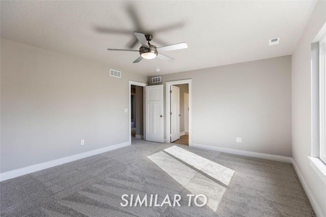 unfurnished bedroom featuring ceiling fan, light colored carpet, and a textured ceiling