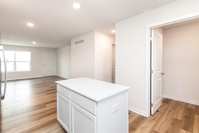 kitchen featuring white cabinets, light wood-type flooring, and a kitchen island