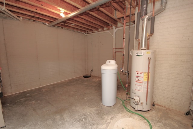 basement with water heater and brick wall