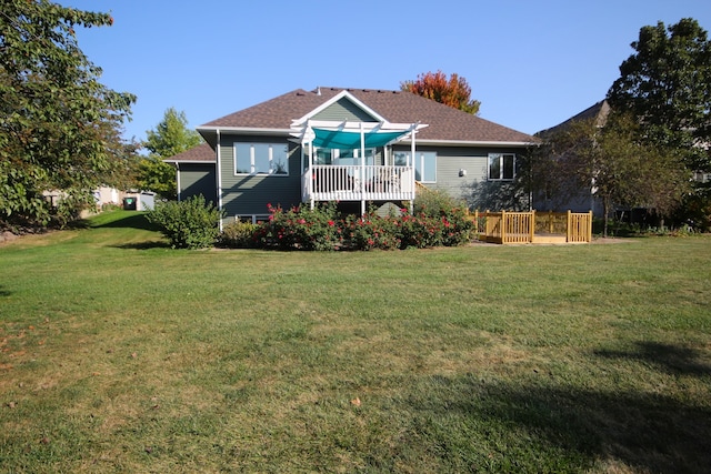 rear view of property featuring a lawn and a deck