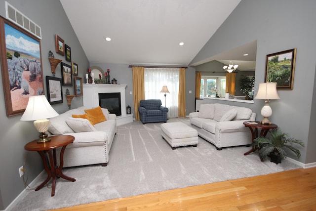 living room featuring vaulted ceiling, a chandelier, and hardwood / wood-style flooring