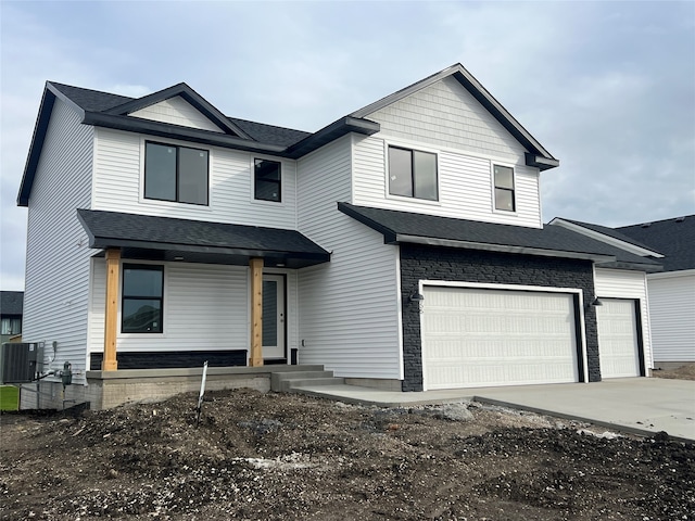 view of front of house featuring a porch, a garage, and central air condition unit