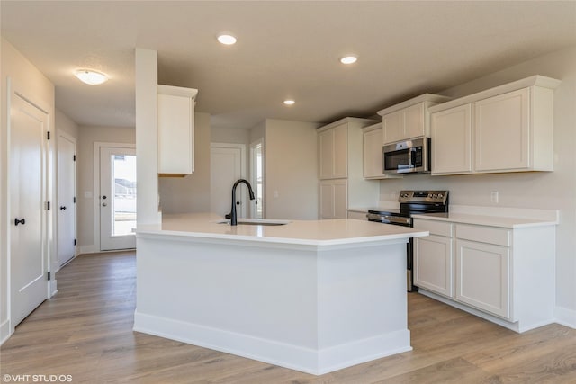 kitchen featuring sink, stainless steel appliances, white cabinetry, and light hardwood / wood-style floors