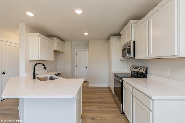 kitchen featuring sink, light hardwood / wood-style floors, white cabinetry, and appliances with stainless steel finishes