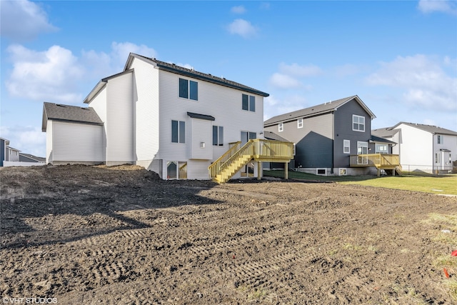 back of house featuring a wooden deck and a yard