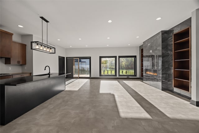 interior space with hanging light fixtures, sink, and a high end fireplace