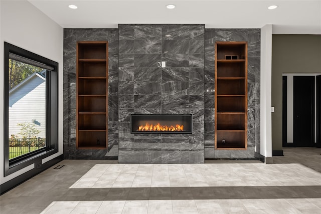 unfurnished living room with tile walls and a premium fireplace