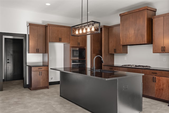 kitchen with sink, an inviting chandelier, a center island with sink, appliances with stainless steel finishes, and decorative light fixtures