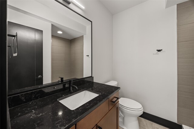 bathroom featuring tile patterned flooring, vanity, and toilet