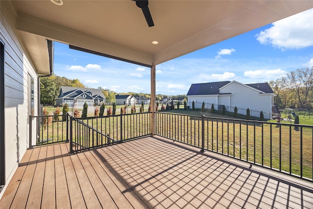 wooden terrace with ceiling fan and a yard