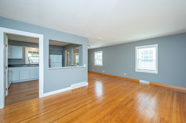 empty room with light wood-type flooring and sink