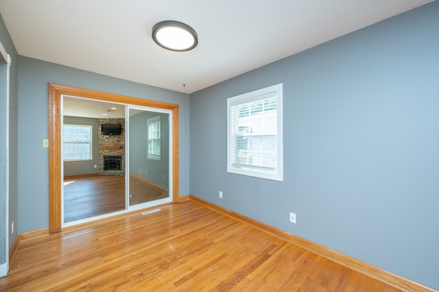 unfurnished room with light hardwood / wood-style flooring and a fireplace