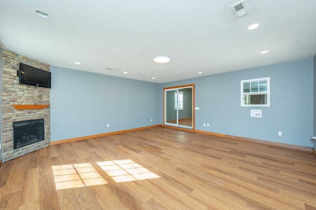 unfurnished living room with light wood-type flooring and a fireplace