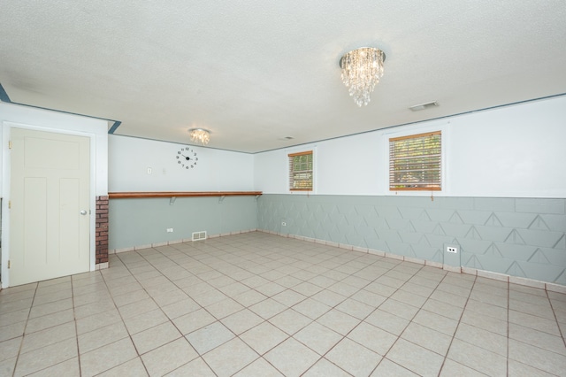 tiled spare room with a textured ceiling