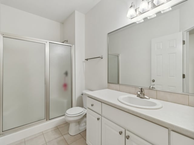 bathroom with vanity, tile patterned flooring, toilet, and an enclosed shower