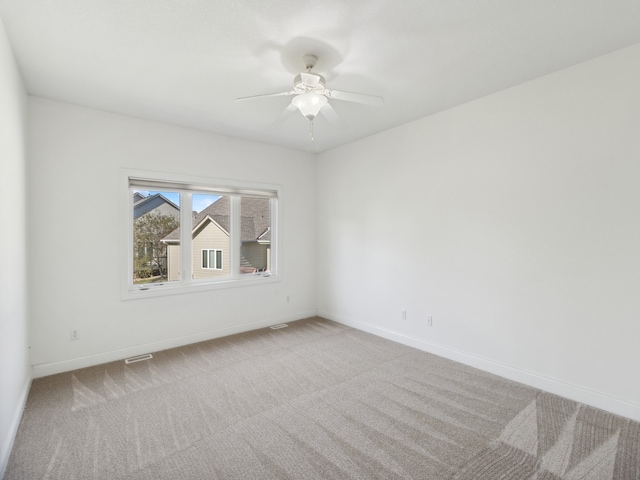 spare room with ceiling fan and light colored carpet