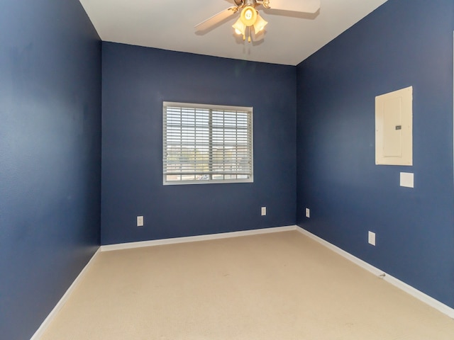 spare room with ceiling fan, electric panel, and carpet