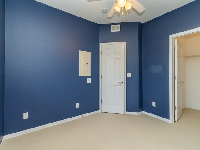 unfurnished bedroom with ceiling fan, light colored carpet, and electric panel