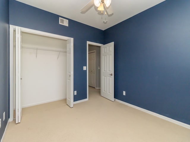 unfurnished bedroom with ceiling fan, a closet, and light carpet