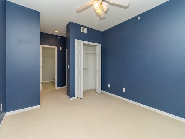 unfurnished bedroom with ceiling fan, light colored carpet, and a closet