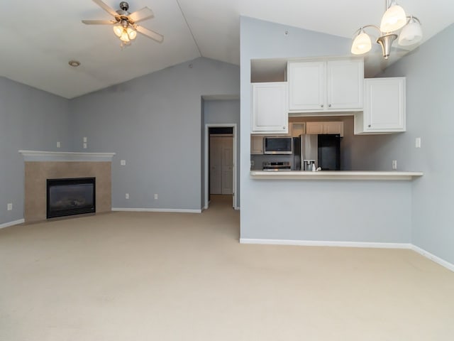 kitchen featuring stainless steel appliances, white cabinets, vaulted ceiling, and decorative light fixtures