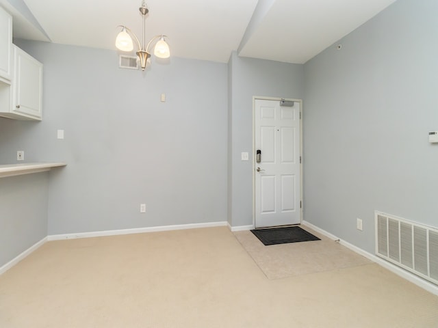 interior space featuring carpet floors and a chandelier