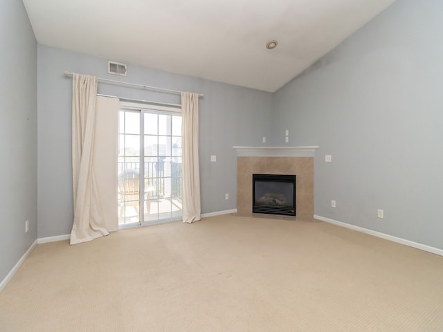 unfurnished living room featuring a tiled fireplace and light carpet