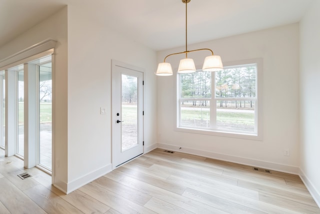 unfurnished dining area with light hardwood / wood-style floors and a healthy amount of sunlight