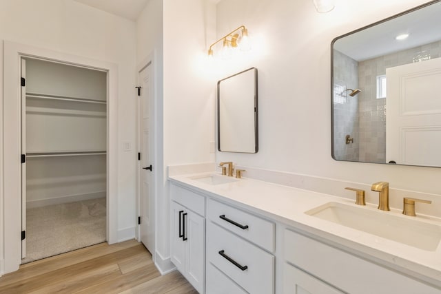 bathroom with a tile shower, hardwood / wood-style floors, and vanity