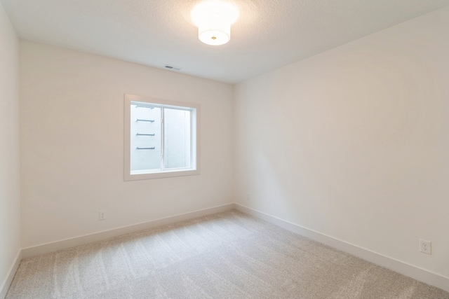 carpeted empty room featuring a textured ceiling