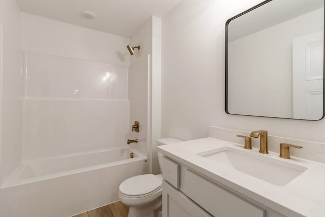 full bathroom featuring vanity, bathtub / shower combination, hardwood / wood-style flooring, toilet, and a textured ceiling