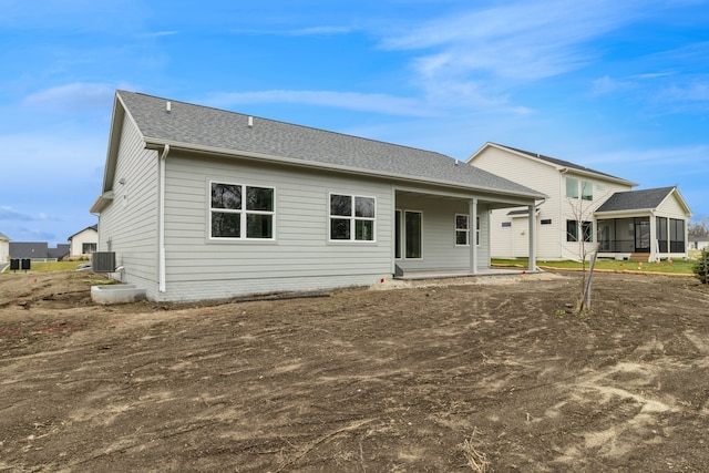 back of property with central AC unit and a sunroom