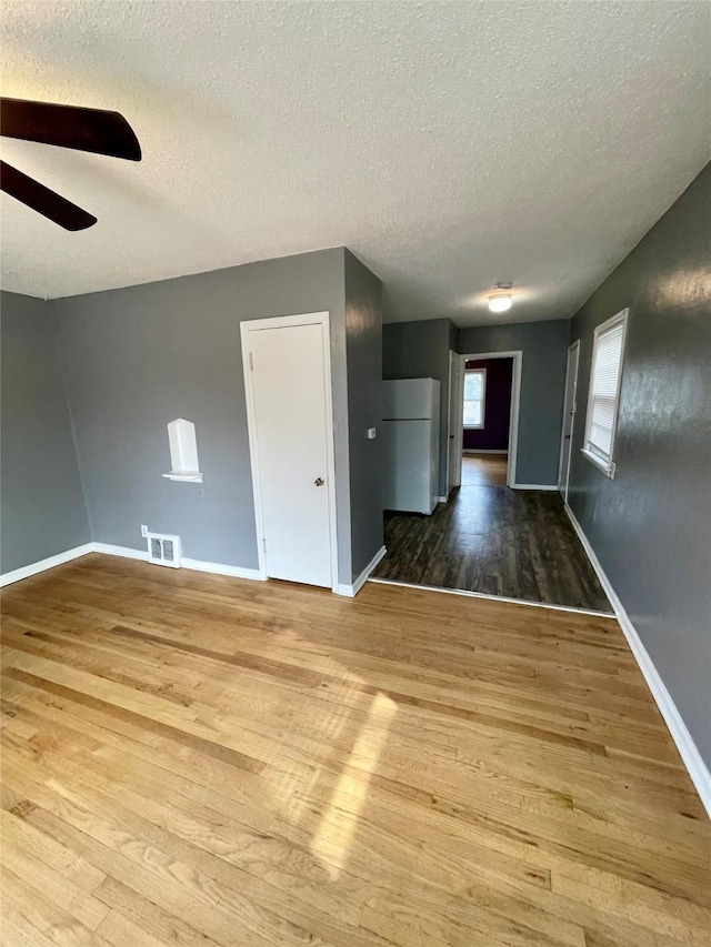 5711 Franklin Ave, Des Moines, IA 50310 - empty room featuring ceiling fan, wood finished floors, a textured ceiling, and baseboards