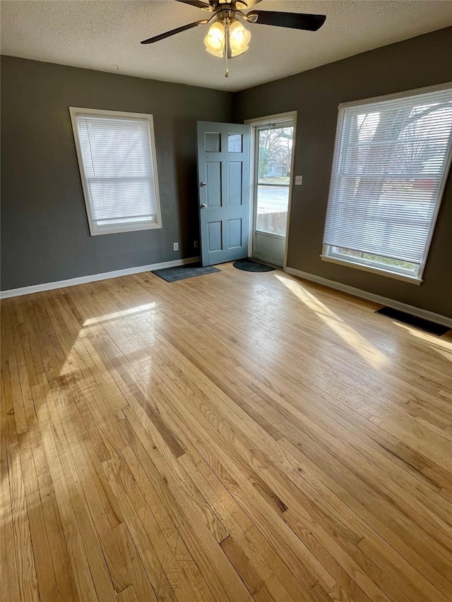 5711 Franklin Ave, Des Moines, IA 50310 - empty room with ceiling fan, light wood-type flooring, baseboards, and a textured ceiling