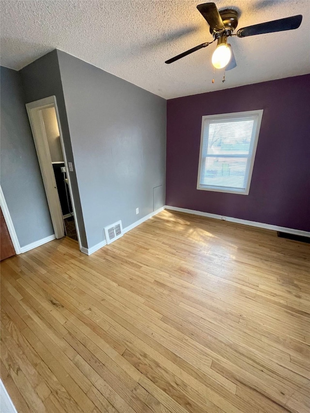5711 Franklin Ave, Des Moines, IA 50310 - unfurnished bedroom featuring light wood-type flooring, a textured ceiling, baseboards, and ceiling fan