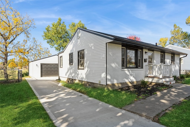 view of front of house with an outdoor structure, a front yard, and a garage