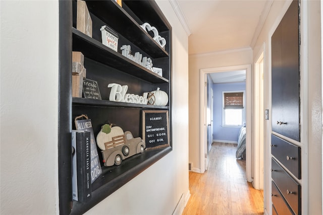 hallway with light hardwood / wood-style floors and crown molding