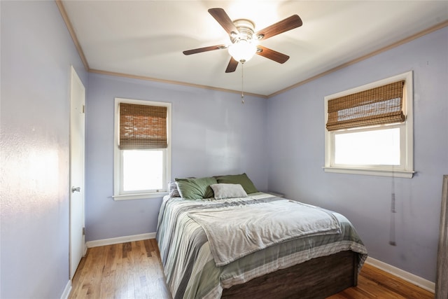 bedroom with light hardwood / wood-style flooring, multiple windows, crown molding, and ceiling fan