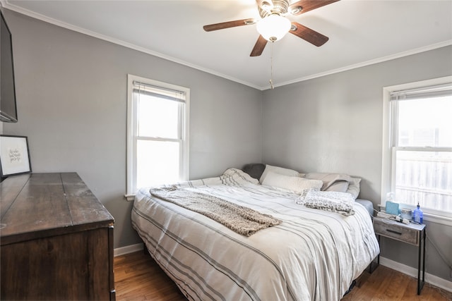 bedroom featuring dark hardwood / wood-style flooring, crown molding, and ceiling fan