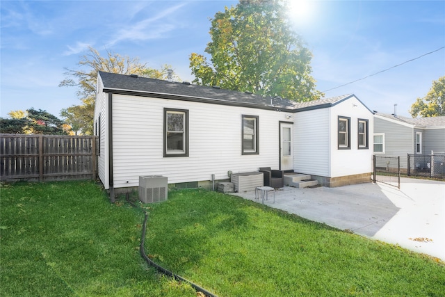 back of house featuring a yard, a patio, and central AC