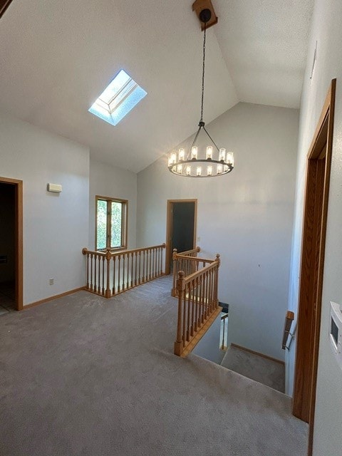 staircase featuring vaulted ceiling with skylight and carpet floors