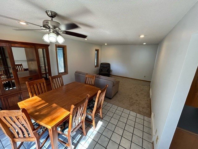 dining area with light carpet, a textured ceiling, and ceiling fan