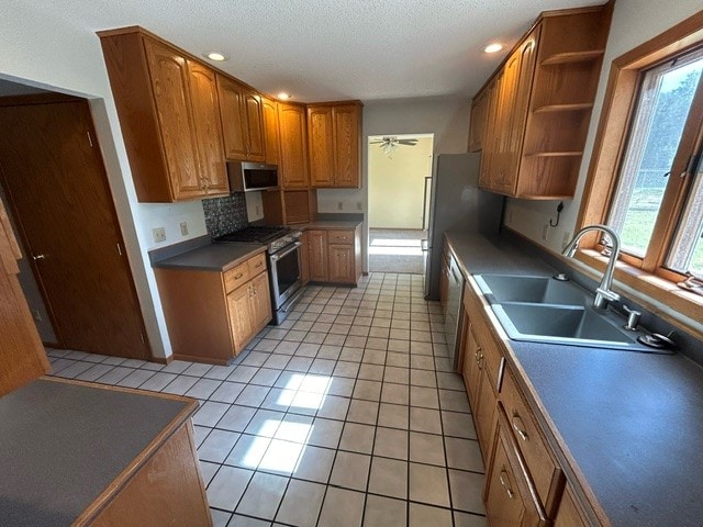 kitchen featuring ceiling fan, light tile patterned floors, sink, a textured ceiling, and stainless steel appliances